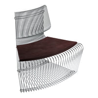 Modern wire chair with a sleek chrome frame and rich brown leather seat, showcasing a contemporary design.