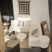 Modern cream sectional sofa with geometric-patterned throw pillows and a black and white accent wall.