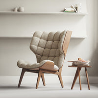 Beige tufted upholstered chair with wooden legs and a minimalist design, complemented by a light wooden side table.