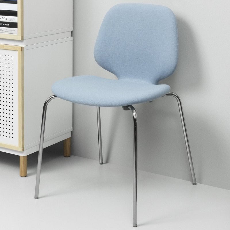 Light blue fabric chair with a smooth, curved design and chrome legs, perfect for modern interiors.