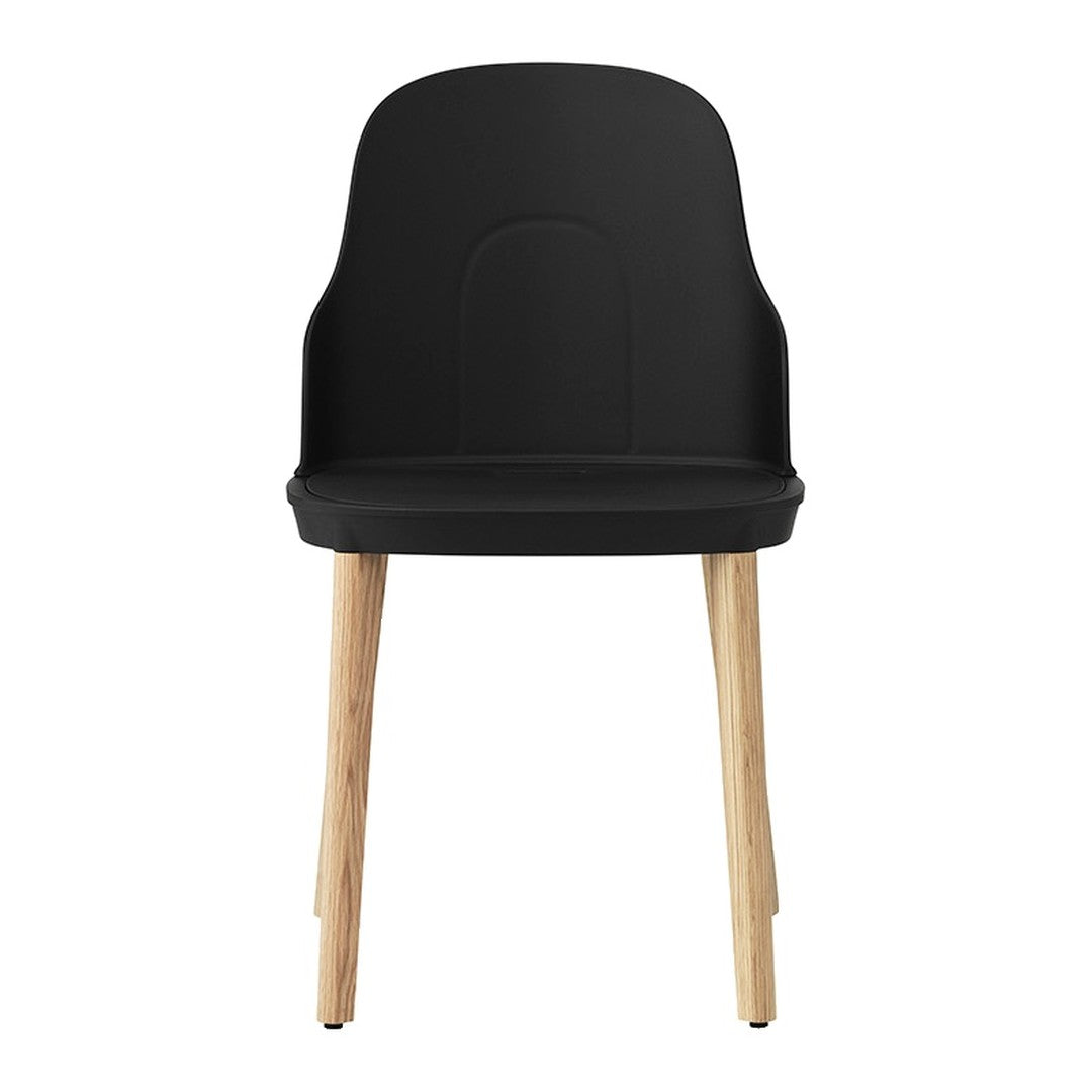 Black chair with a smooth, curved back and light wood legs, showcasing a minimalist design. Perfect for modern decor.
