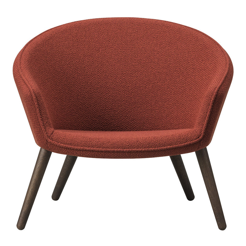 Rust-colored upholstered chair with a cozy, rounded design and dark wooden legs. Perfect for modern interiors.