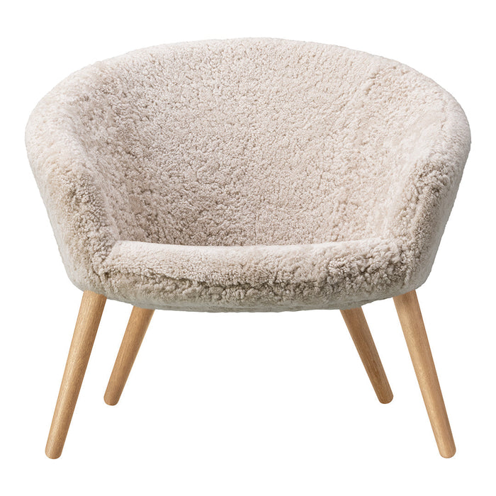 Beige fluffy armchair with textured fabric and light wooden legs, perfect for a cozy living space.
