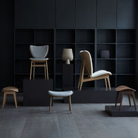 Modern furniture display featuring neutral tones, wooden accents, and minimalist patterns against a dark backdrop.