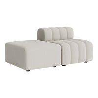 Cream-colored lounge sofa with smooth, modern lines and subtle ribbed detailing. Ideal for contemporary interiors.
