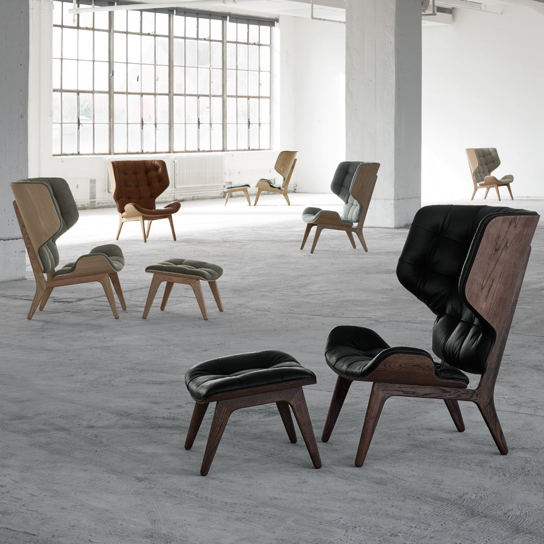 Stylish mid-century chairs in brown and black upholstery with sleek wooden legs, ideal for modern decor.