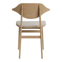 Light oak folding chair with a simple, curved backrest and a neutral upholstered seat.