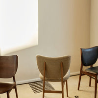 Three stylish chairs in earthy tones: wood, beige, and dark blue, showcasing a modern, minimalist design.