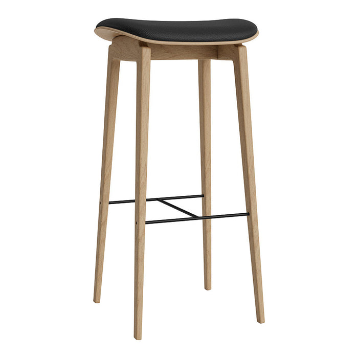 Black curved seat on natural wood legs with a sleek black metal footrest. Modern and minimalist design.