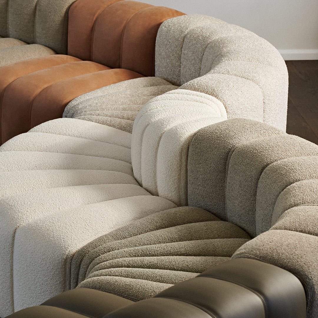 "Curved sectional sofa featuring beige, brown, and olive green tones with textured patterns for modern decor."