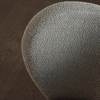 Textured gray upholstery pattern on a rounded chair surface, contrasting with a dark wooden floor.