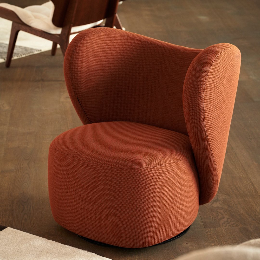 Soft orange accent chair with smooth curves and a modern design, perfect for stylish interiors.