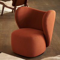 Soft orange accent chair with smooth curves and a modern design, perfect for stylish interiors.
