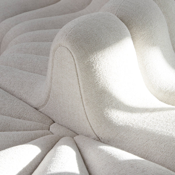 Textured cream fabric with subtle wave pattern, featuring soft curves and play of light and shadow.