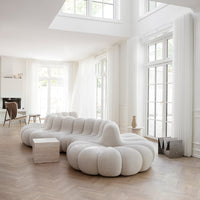 "Textured white sofa with a modern, curved design, set against a bright, airy room with natural light."