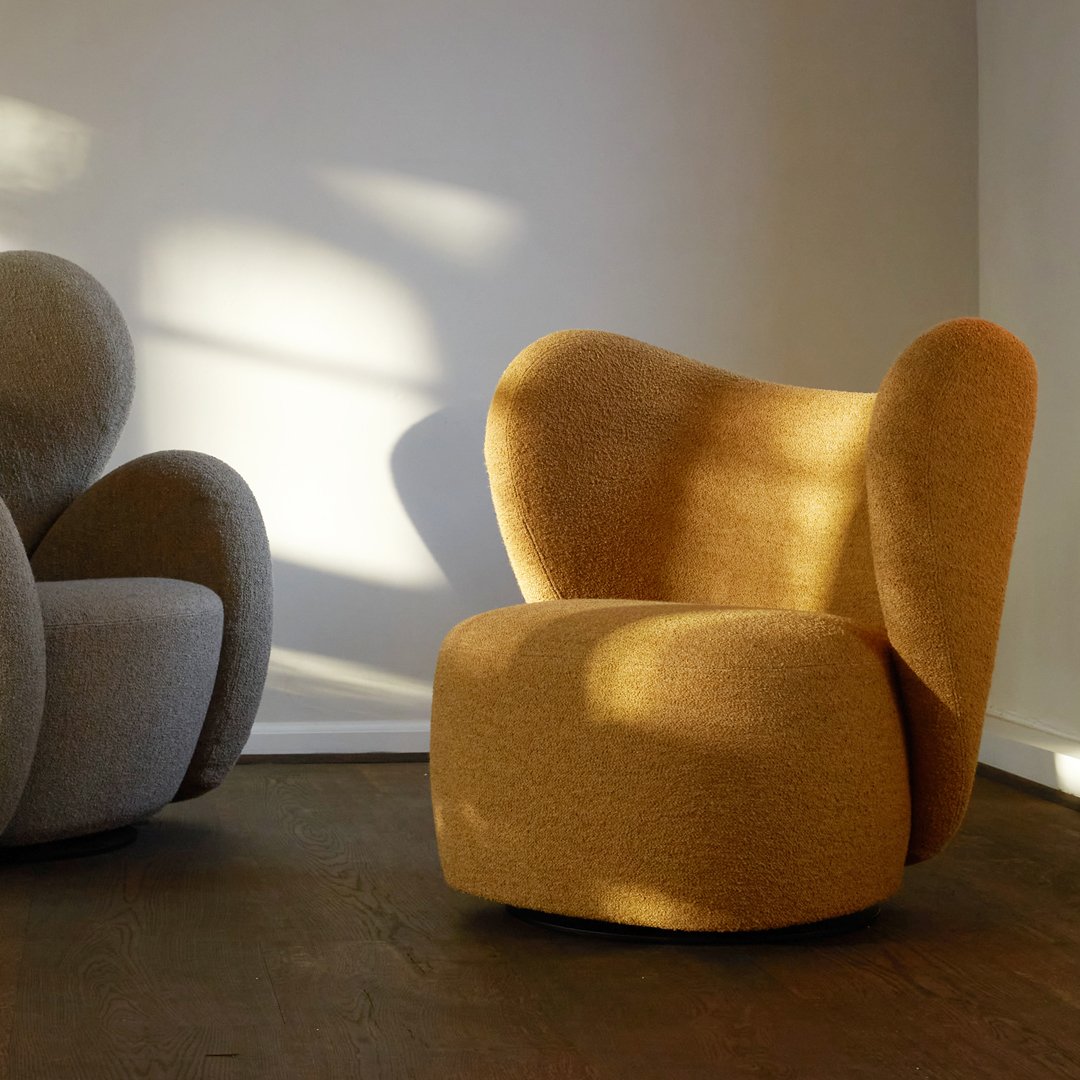 Textured mustard yellow armchair with a modern design, paired with a soft gray chair in a bright, sunlit room.