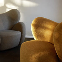 "Soft gray and warm mustard yellow accent chairs with smooth, rounded shapes and textured fabric."