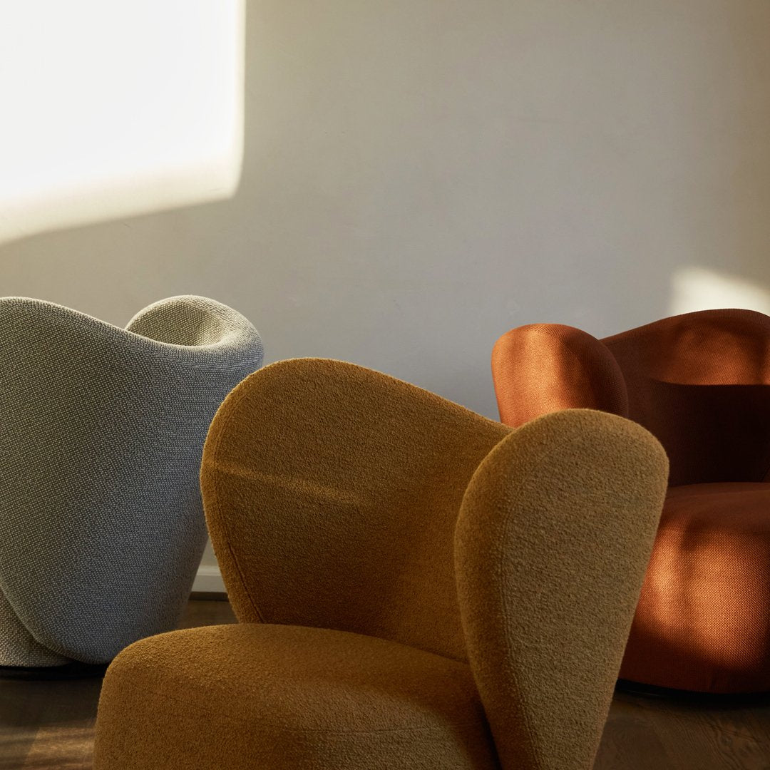 Colorful modern chairs in soft textures: light gray, warm mustard, and rich rust tones with organic shapes.
