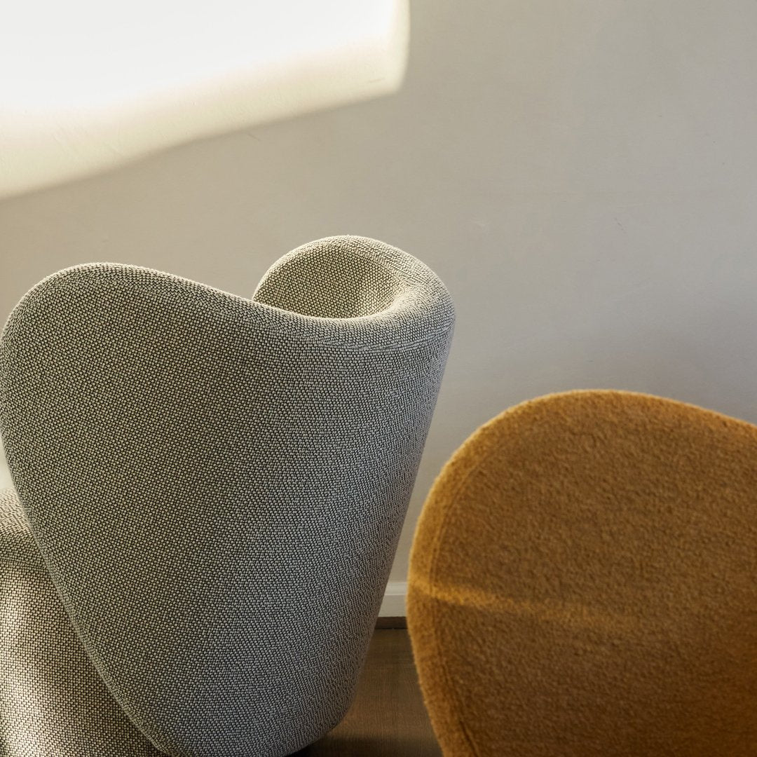 Curved chairs in soft grey and warm mustard, featuring smooth textures and modern shapes. Ideal for stylish decor.