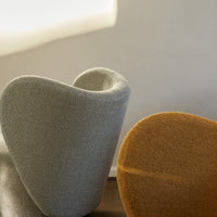 Curved chairs in soft grey and warm mustard, featuring smooth textures and modern shapes. Ideal for stylish decor.
