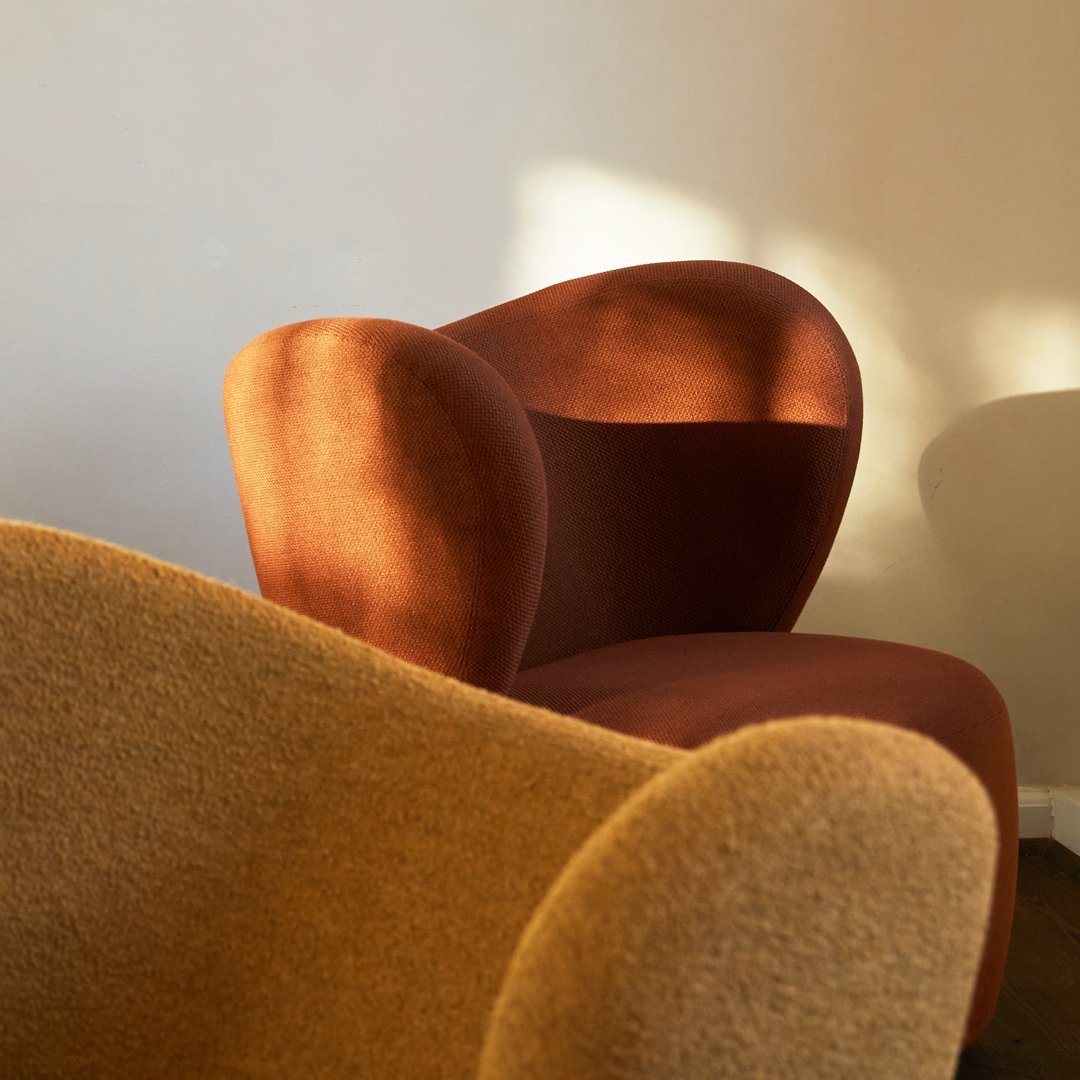 "Textured orange and brown lounge chairs with smooth curves, set against a neutral backdrop."
