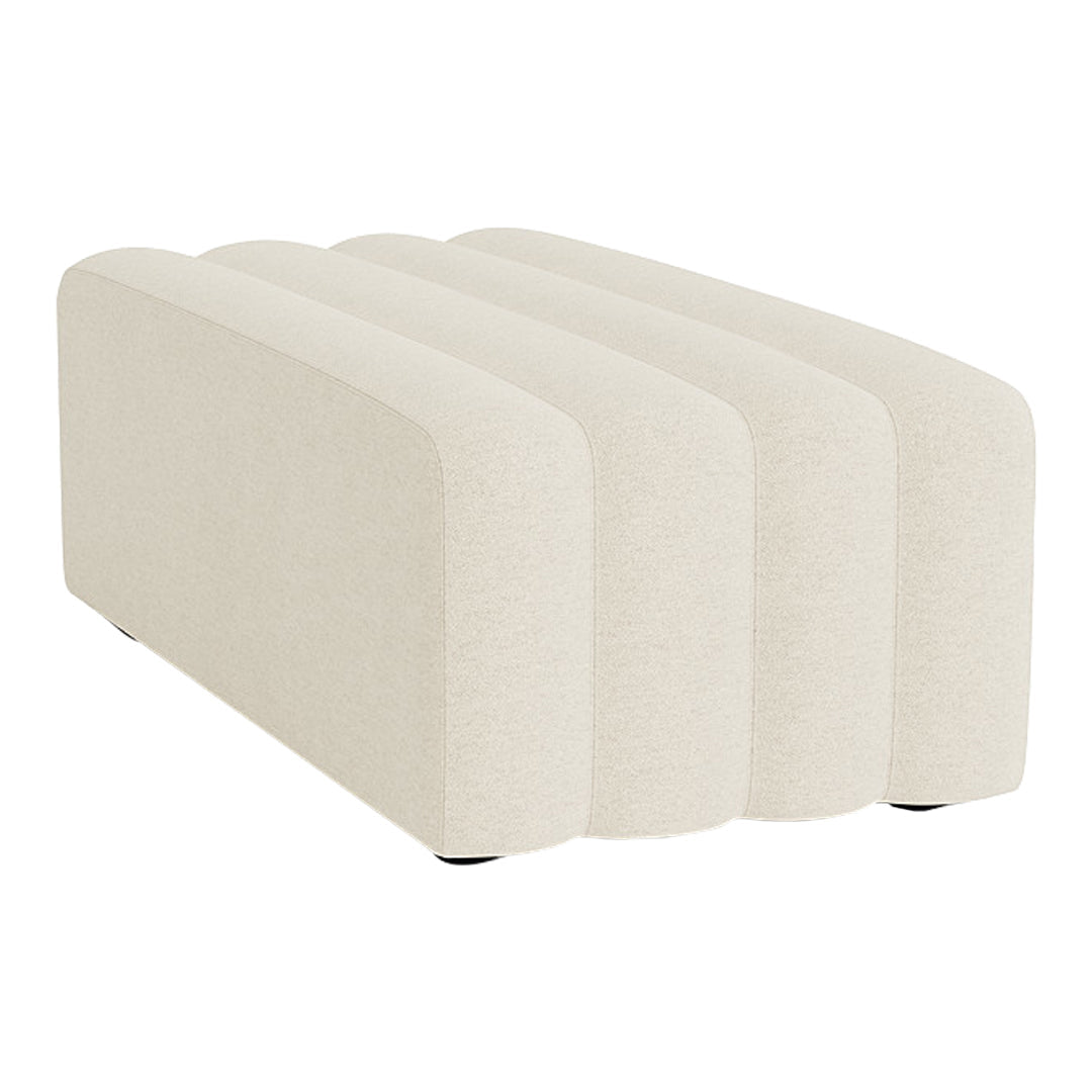 Off-white, plush upholstered ottoman with smooth, curved edges and a minimalistic design.