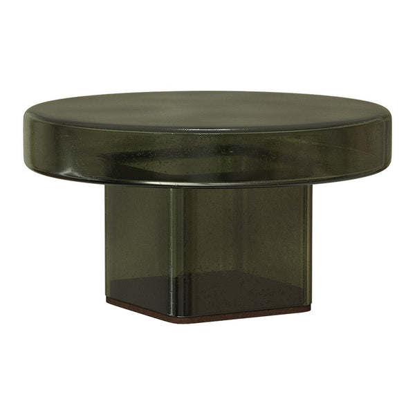 Green glass coffee table with a smooth round top and geometric base, featuring a modern, minimalist design.