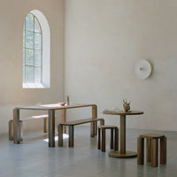 Natural wood furniture with warm brown tones and light gray flooring, set against a soft beige wall.