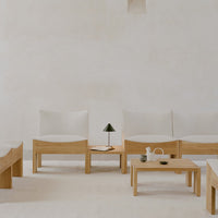 Minimalist wood chairs with light beige cushions on a neutral backdrop, complemented by natural wooden tables.