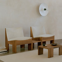 Beige and cream upholstered chairs with textured fabric against a neutral background and wooden accents.