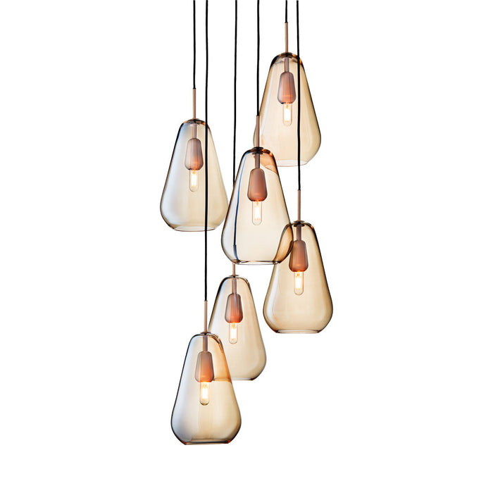 Set of six teardrop pendant lights in amber and clear glass with warm copper accents. Modern, sleek design.