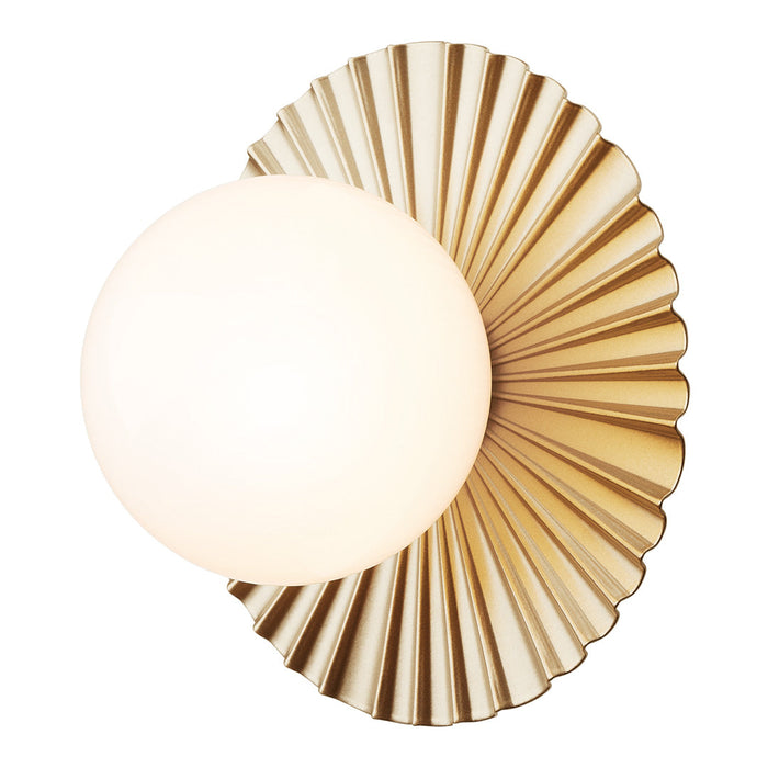 Elegant gold wall sconce featuring a fluted design and a round white glass bulb for a modern touch.