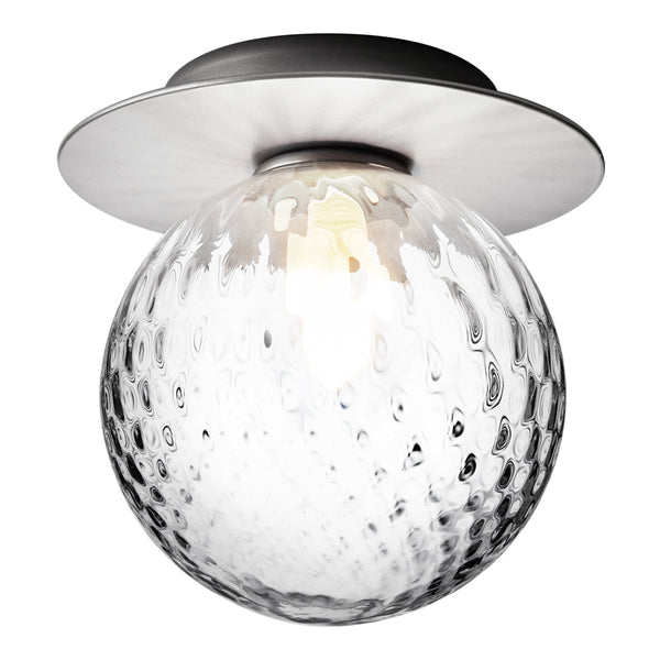 Clear glass globe light with textured pattern, metal base in sleek black finish, modern design accent for any decor.