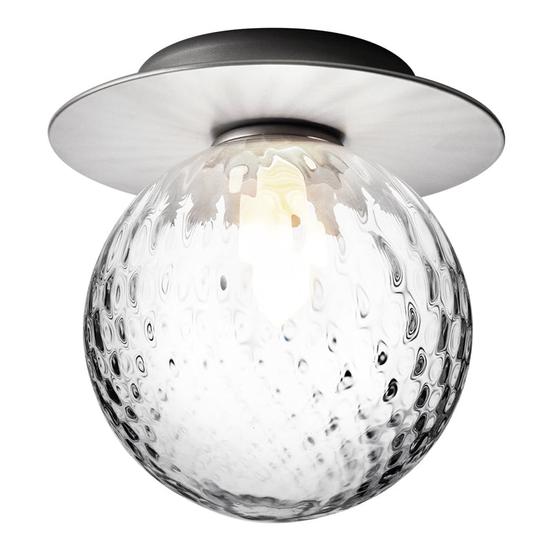 Clear glass globe light with textured pattern, metal base in sleek black finish, modern design accent for any decor.