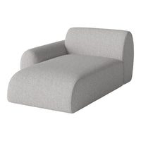 Light gray upholstered chaise lounge with a textured finish and soft, rounded edges. Modern, minimalist design.