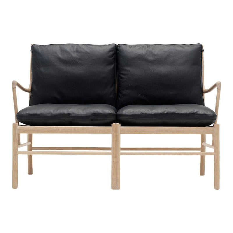 Black leather loveseat with a light wood frame, featuring a modern, minimalist design and sleek lines.
