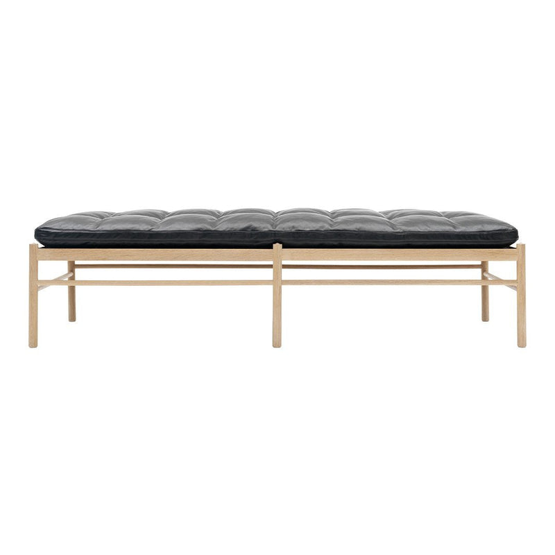 Black tufted cushion on a natural wood frame, featuring simple lines and a modern design. Ideal for contemporary spaces.