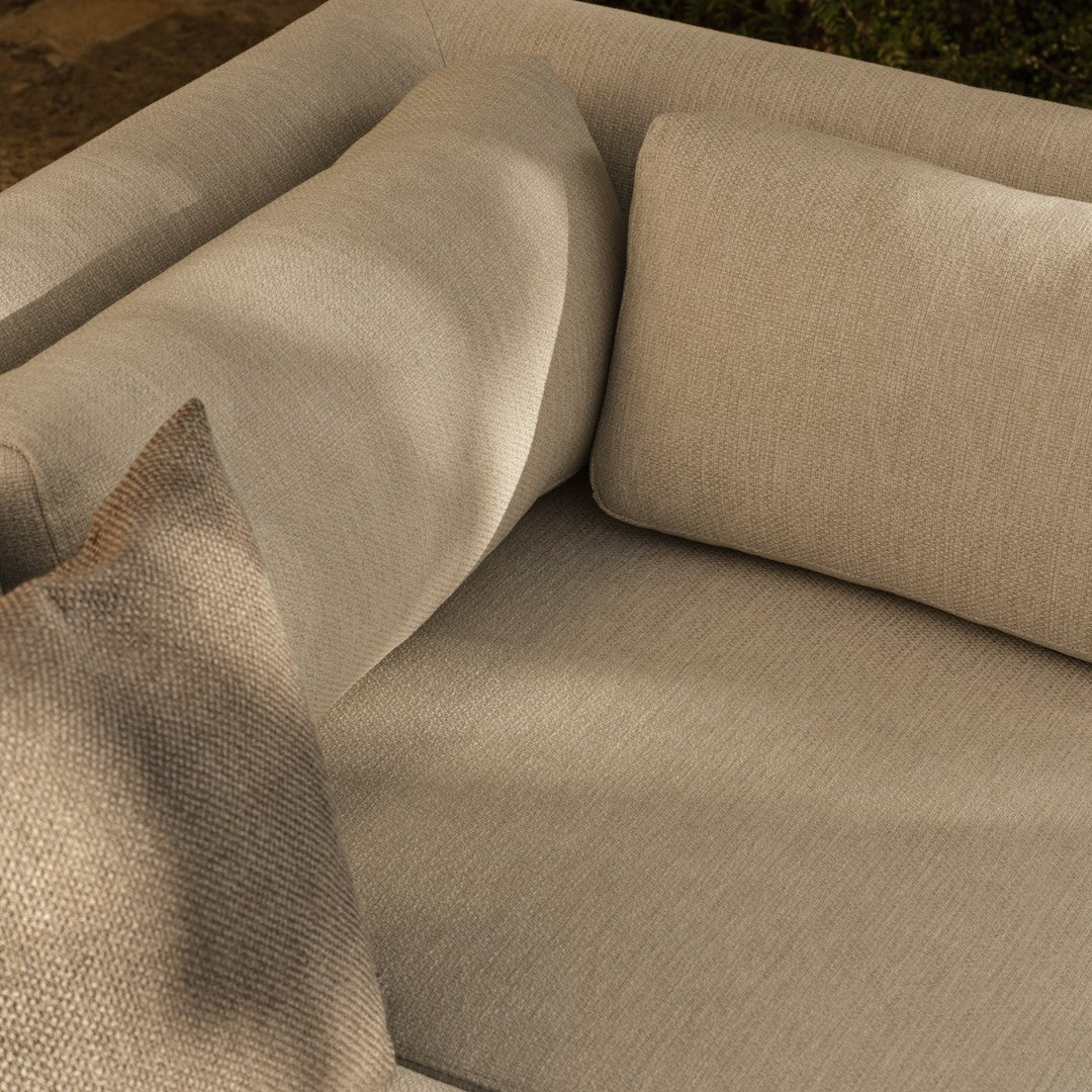Beige and light gray sofa with a textured throw pillow, featuring a minimalistic and modern design.