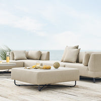 Beige outdoor sectional sofa with plush cushions, modern design, and minimalistic style, perfect for coastal settings.