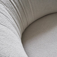 Close-up of soft, textured beige fabric with subtle lines and a smooth, rounded surface. Ideal for modern decor.
