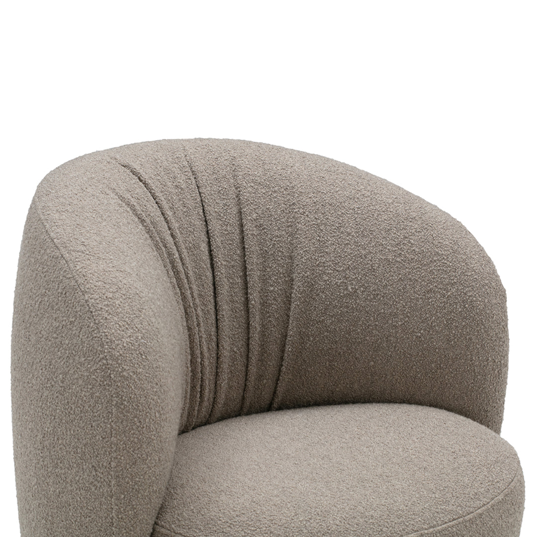 Soft beige upholstered chair with a rounded shape and tufted texture, perfect for modern decor.