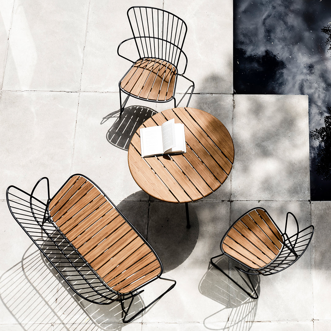 Wooden patio furniture set with black metal frames and slatted design, featuring a round table and two matching chairs.