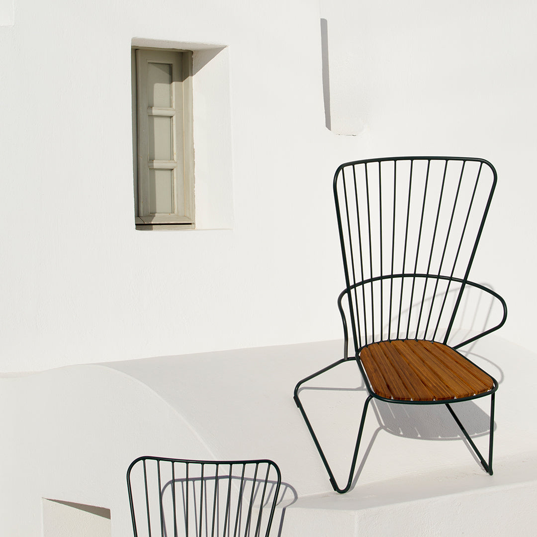Black wire chair with a natural wood seat, set against a minimalist white background. Stylish and modern design.