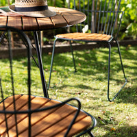Stylish outdoor furniture set featuring a round wooden table with black metal legs and matching wood seat chairs.