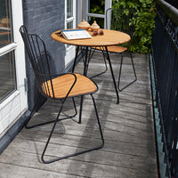 Black metal chairs and table with bamboo tops, featuring a sleek, modern design for outdoor relaxation.