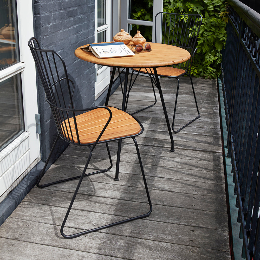 Black metal chairs and table with bamboo tops, featuring a sleek, modern design for outdoor relaxation.