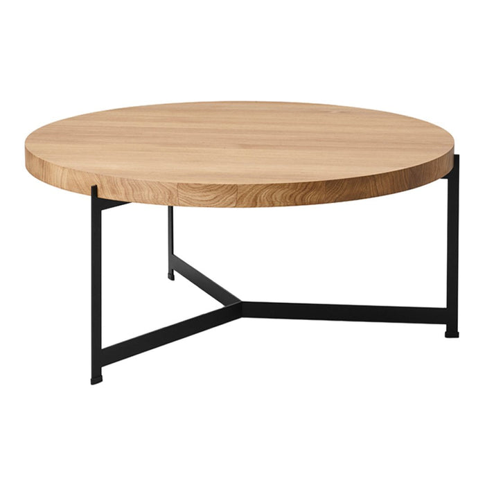 Round wooden coffee table with a light oak top and a sleek black metal base. Simple and modern design.