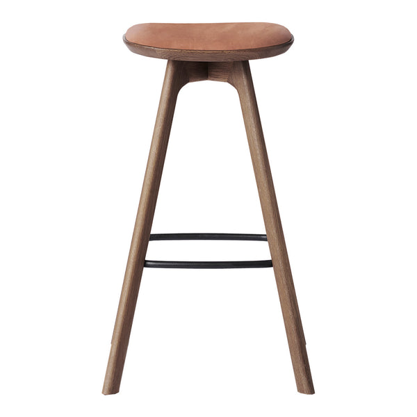 "Stylish wooden bar stool with a natural finish and a smooth tan seat, featuring minimalist design and sleek black accents."