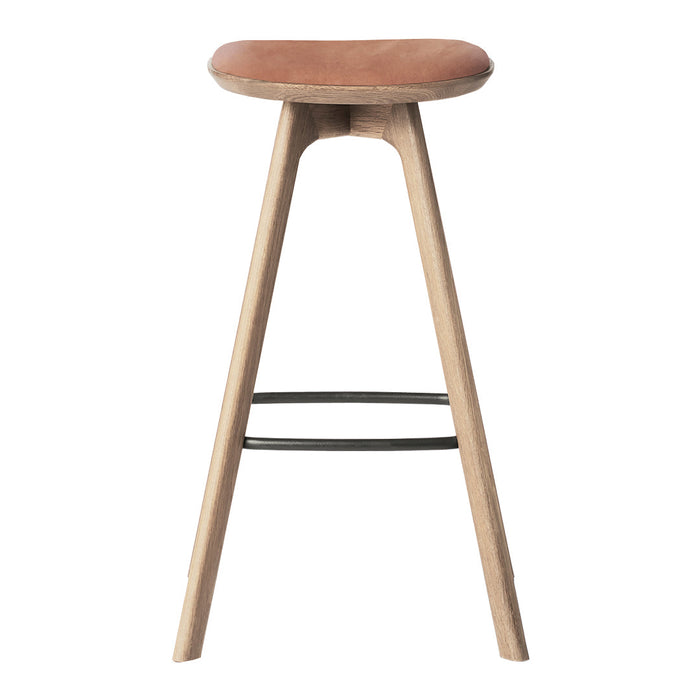 Natural wood bar stool with a curved brown leather seat and minimalist black metal footrest.
