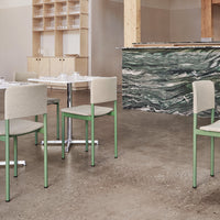Light gray upholstered chairs with mint green legs beside a textured, dark green and white marbled bar.